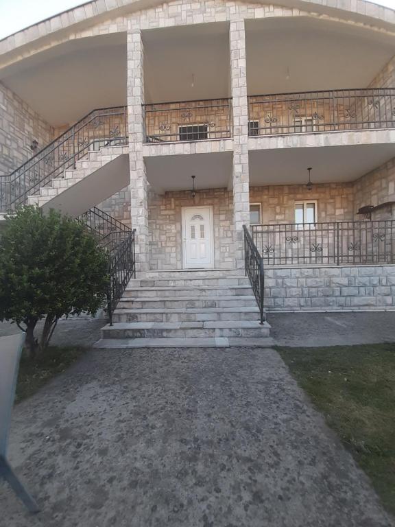 ein Gebäude mit einer Treppe und einer weißen Tür in der Unterkunft VILA LUKA in Podgorica