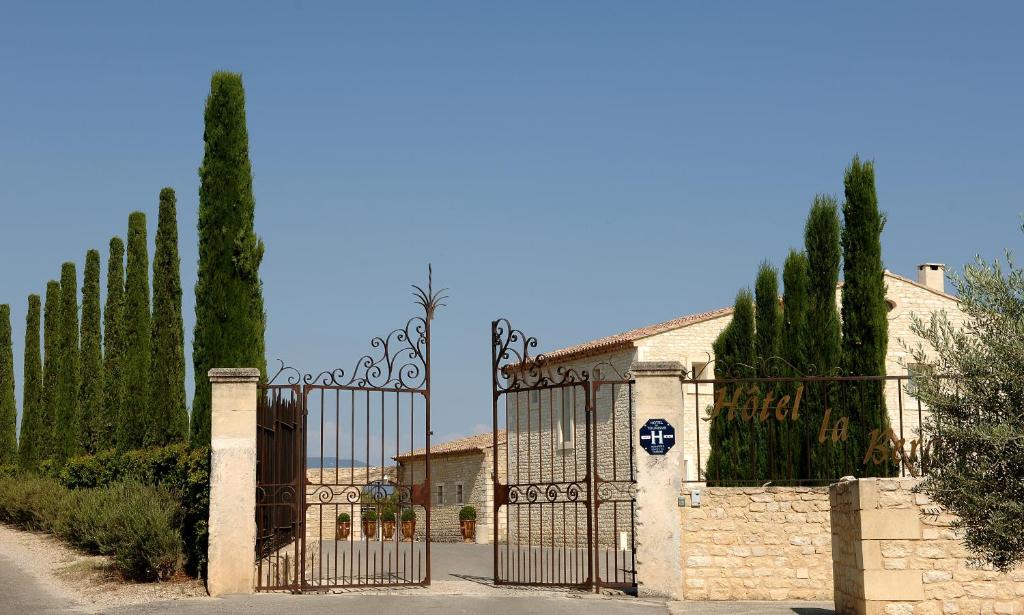 a gate in front of a building with trees at La Bergerie in Joucas