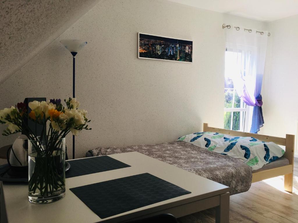 a bedroom with a table with a vase of flowers at U Wróbelka in Grzybowo
