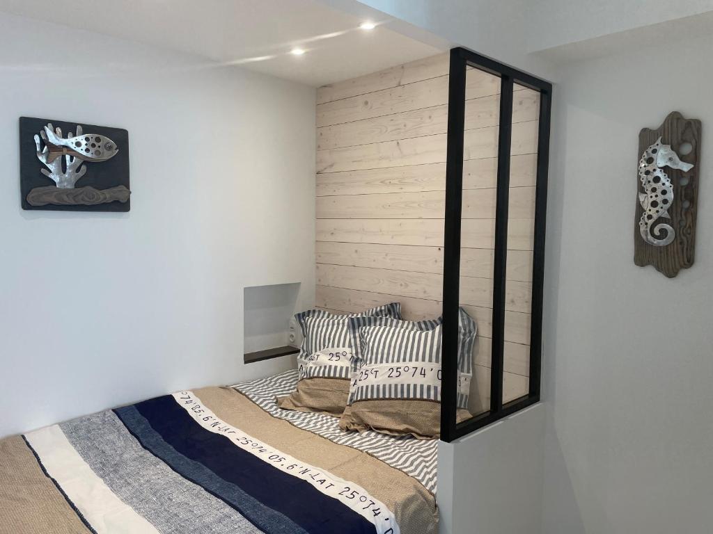 a bedroom with a bed with a mirror on the wall at Le Petit Navire in La Flotte