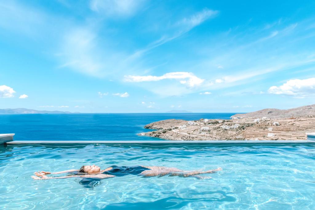een vrouw die zwemt in een zwembad in de oceaan bij Casa Eutopia in Agios Romanos