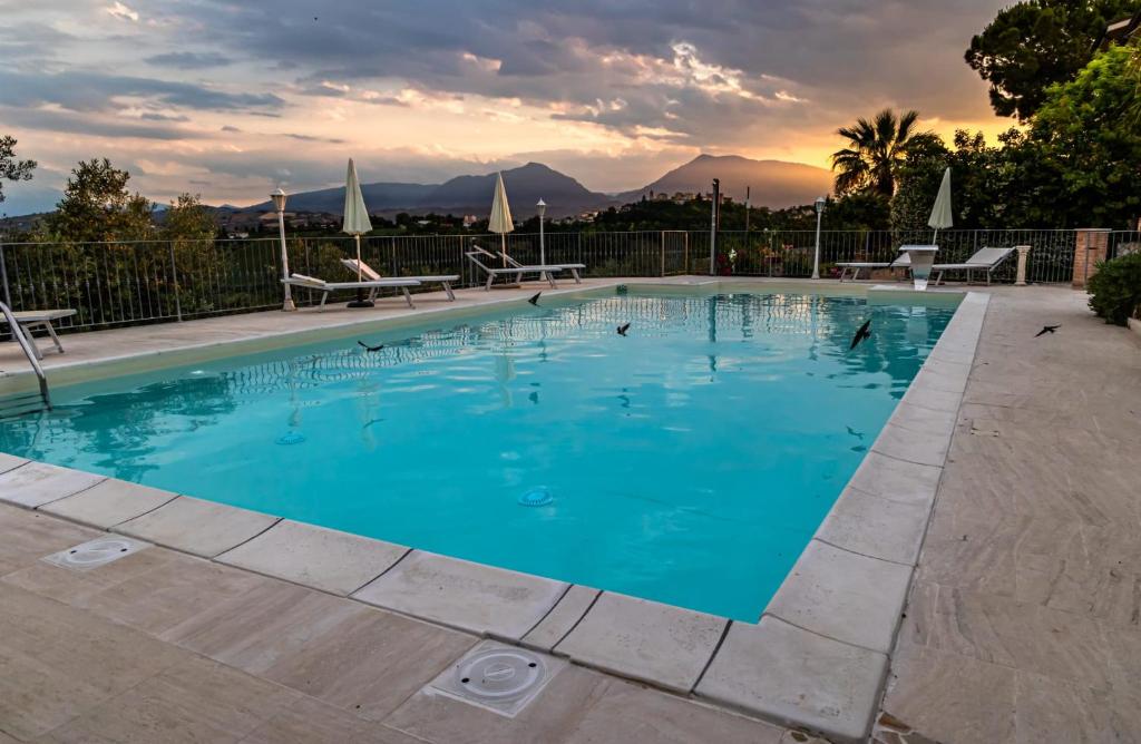 a large swimming pool with blue water at Anthos Casa Vacanze in SantʼOmero