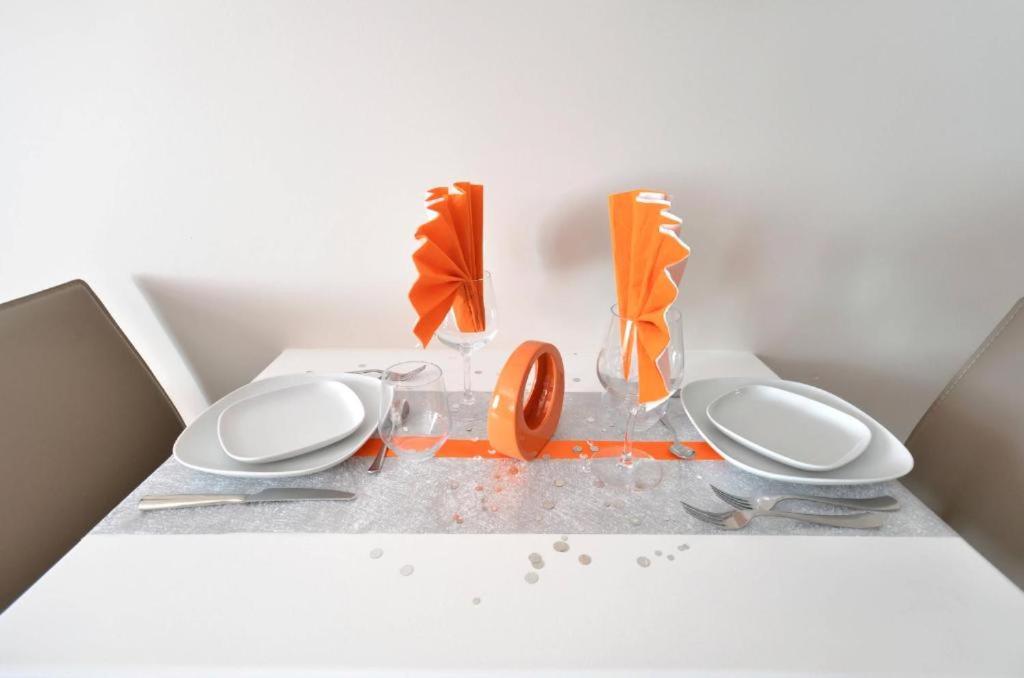 a white counter with two plates and an orange vase at Orange Studio Paris Disneyland in Serris