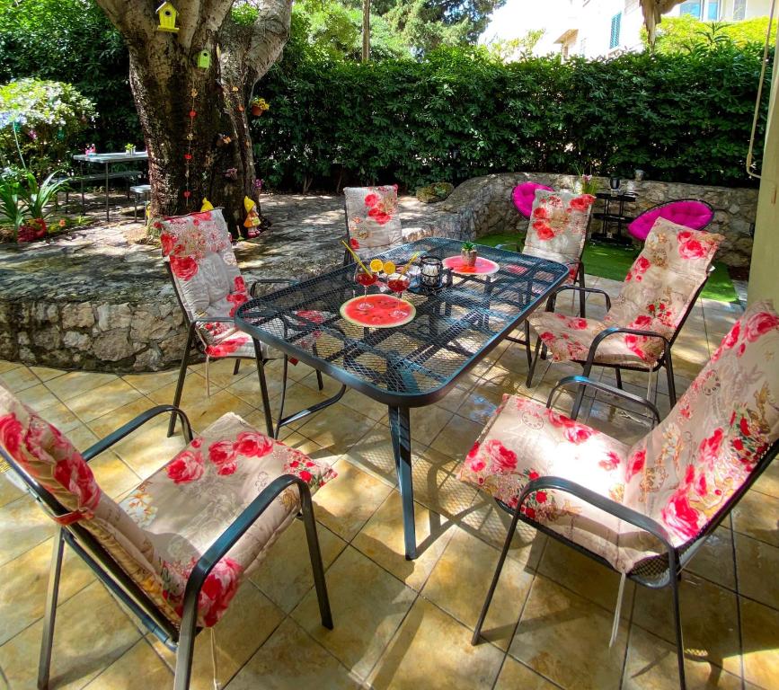 a glass table and chairs on a patio at Relax Apartment Lapad Dubrovnik in Dubrovnik