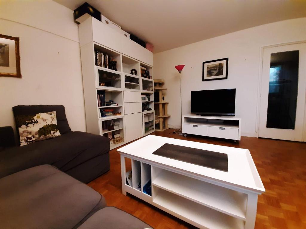 sala de estar con sofá y mesa de centro en 2 bedrooms Apartment with parking Paris Neuilly, en Neuilly-sur-Seine