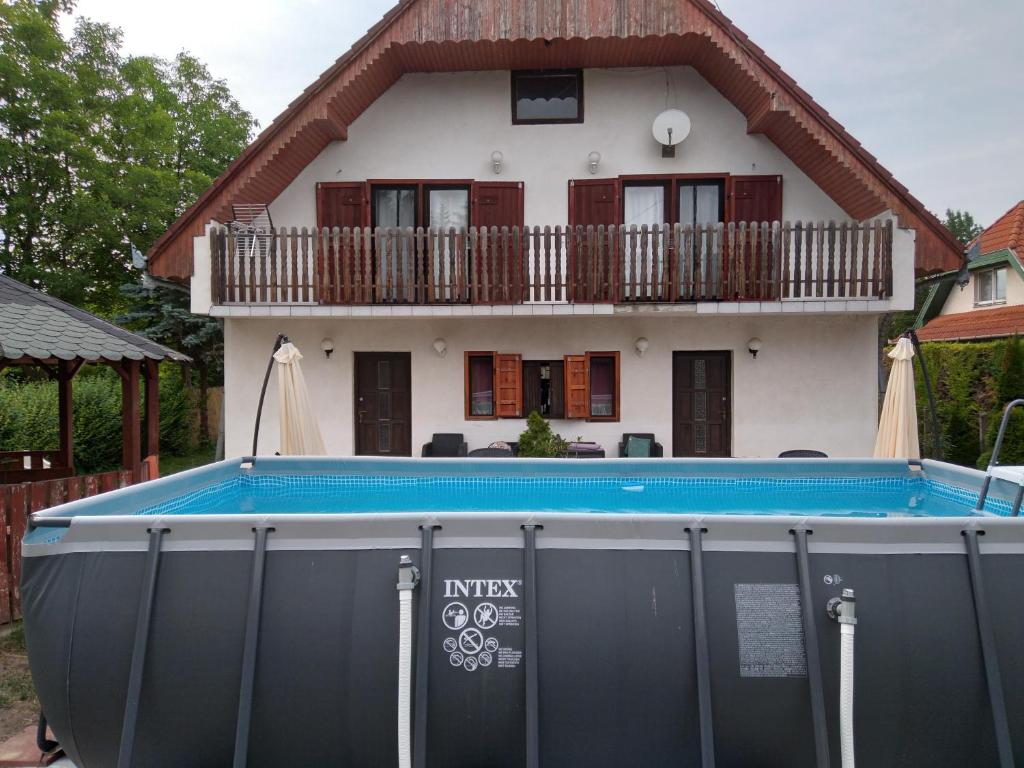 a house with a swimming pool in front of a house at Kiss Apartman in Balatonberény