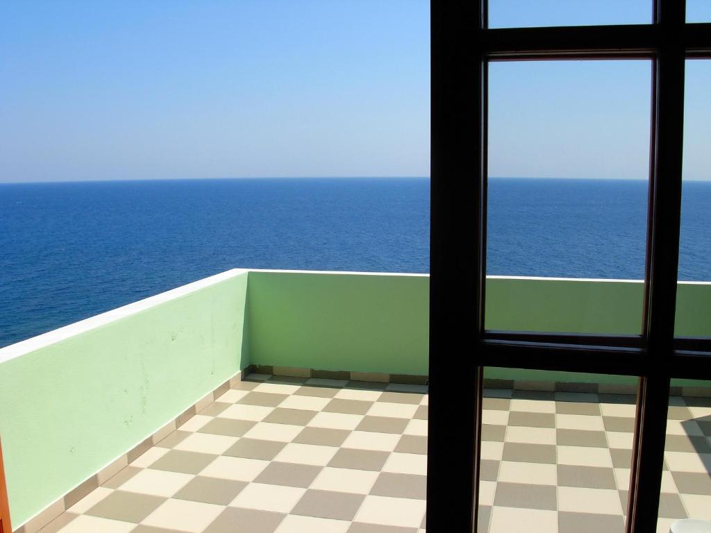 a balcony overlooking the ocean with a view of the ocean at Faros in Milopotamos