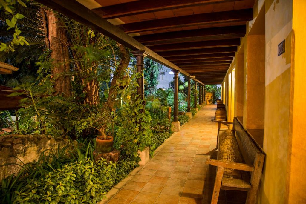 a walkway with plants on the side of a building at Hotel Las Farolas in Antigua Guatemala