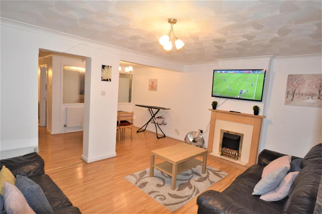 a living room with a couch and a tv at Spacious 3 bedroom House in Tilbury by London in Low Street