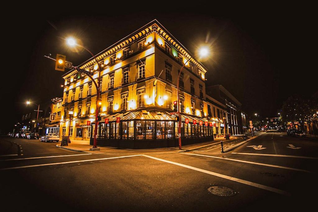 un edificio iluminado en una calle de la ciudad por la noche en Swans Brewery, Pub & Hotel, en Victoria