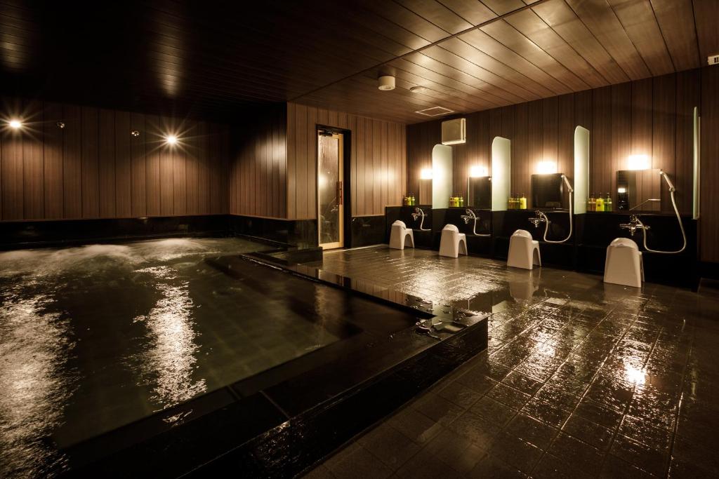 - une piscine dans une pièce avec des chaises et des lumières dans l'établissement S-peria Hotel Kyoto, à Kyoto