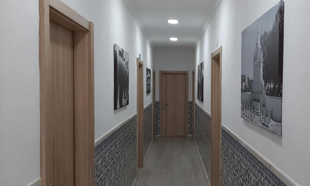 um corredor com muitas imagens nas paredes em Hostel de Borba - Just In House em Borba