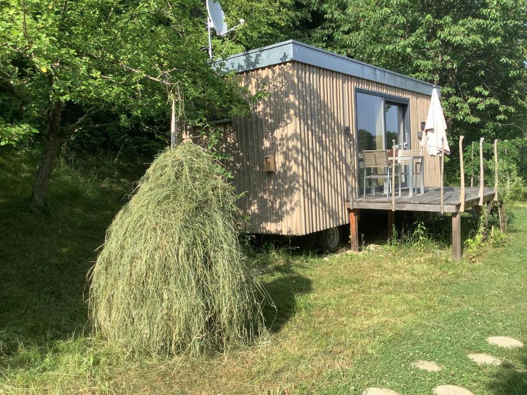 ein großer Heuhaufen neben einem winzigen Haus in der Unterkunft Tiny House Steirermadl in Birkfeld