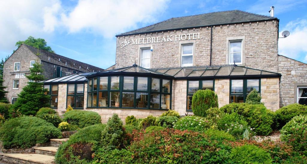 a building with a garden in front of it at The Melbreak Hotel in Great Clifton