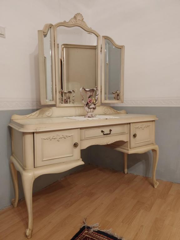 a white vanity with a mirror and a sink at Rokoko Apartman in Abádszalók