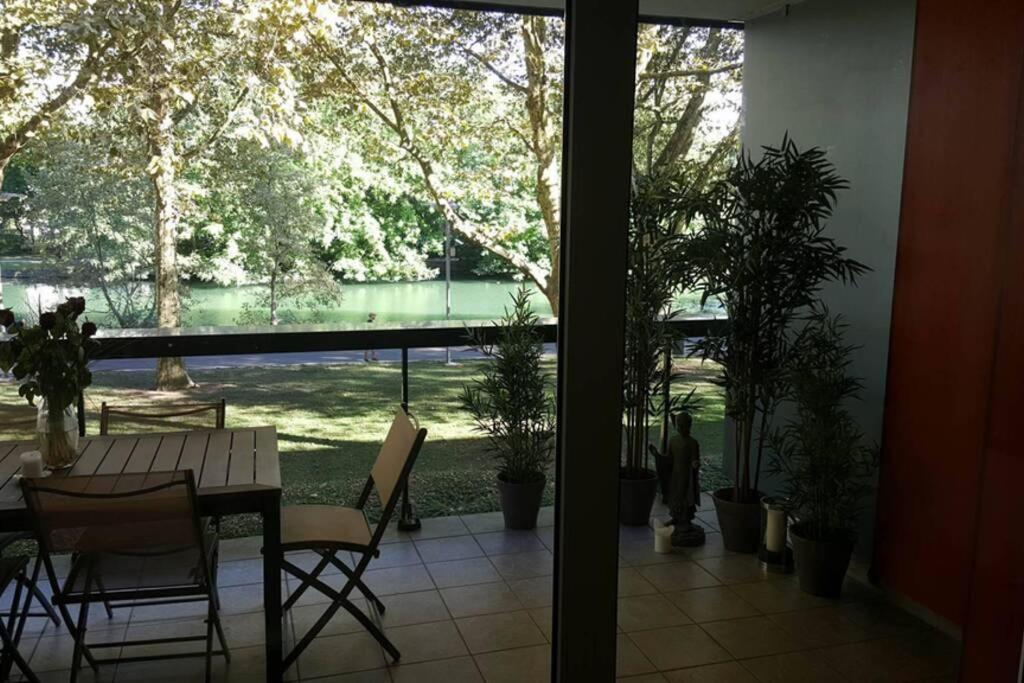 a view of a patio with a table and chairs and plants at Superbe Duplex au Nouveau Bassin avec vue superbe in Mulhouse