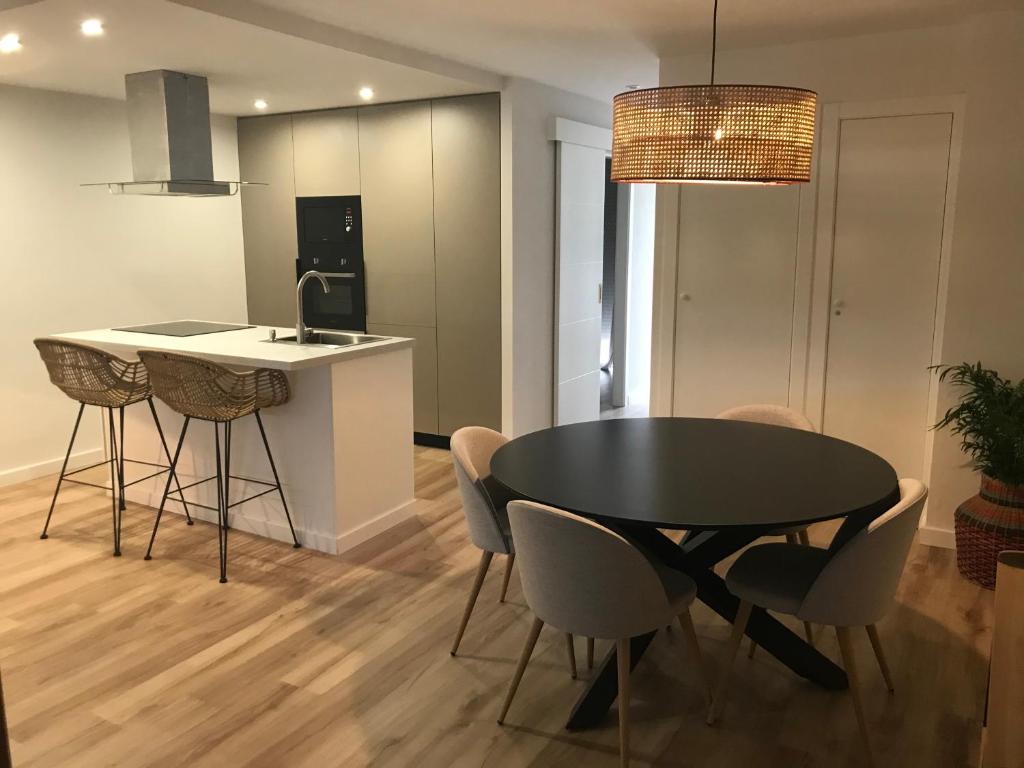 a kitchen and dining room with a black table and chairs at Apartamento Torrevieja in Torrevieja