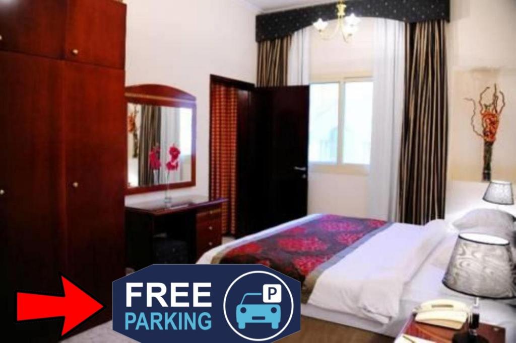 a bedroom with a bed with a sign free parking at Al Sharq Hotel Suites - BAITHANS in Sharjah