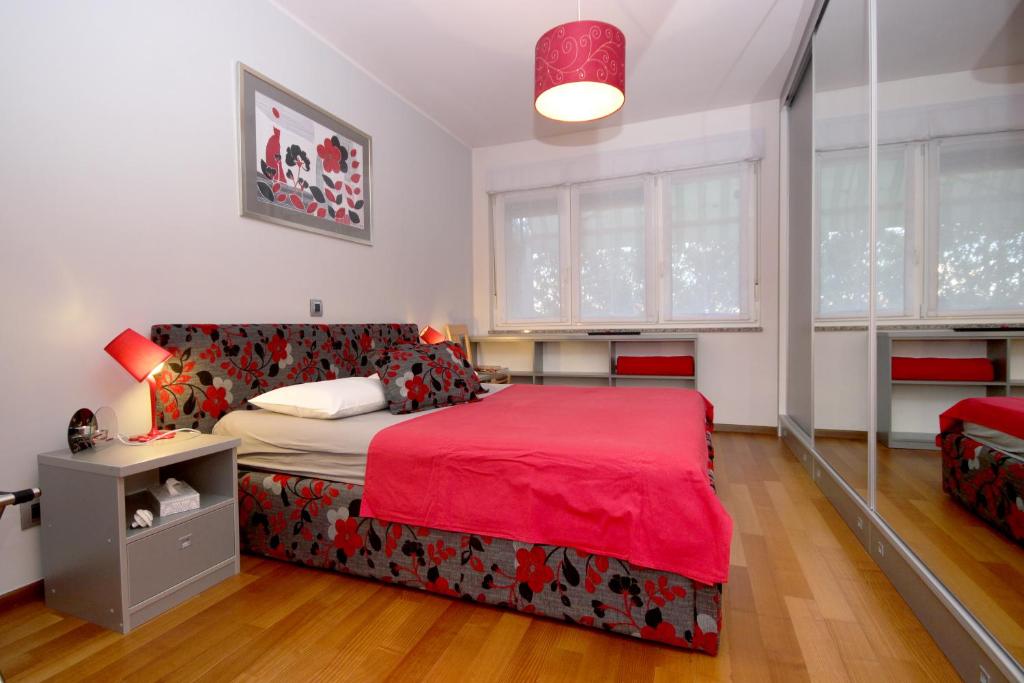 a bedroom with a bed and a couch with a red blanket at Apartment Bizjak in Pula