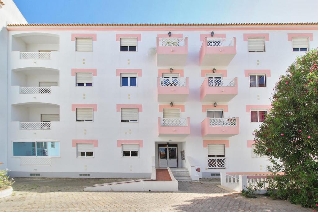 um grande edifício branco com varandas cor-de-rosa em Prestige For Home - Apartamento T2 - Lagos em Lagos