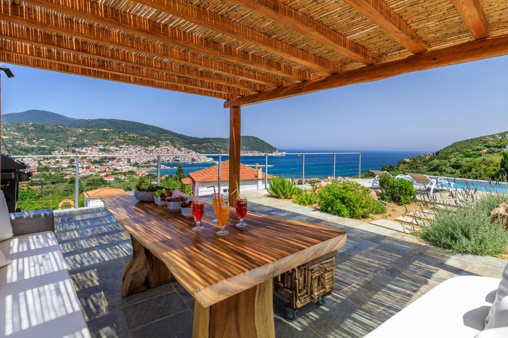 - une table en bois sur une terrasse avec vue sur l'océan dans l'établissement Villa Myli - Skopelos, à Skopelos