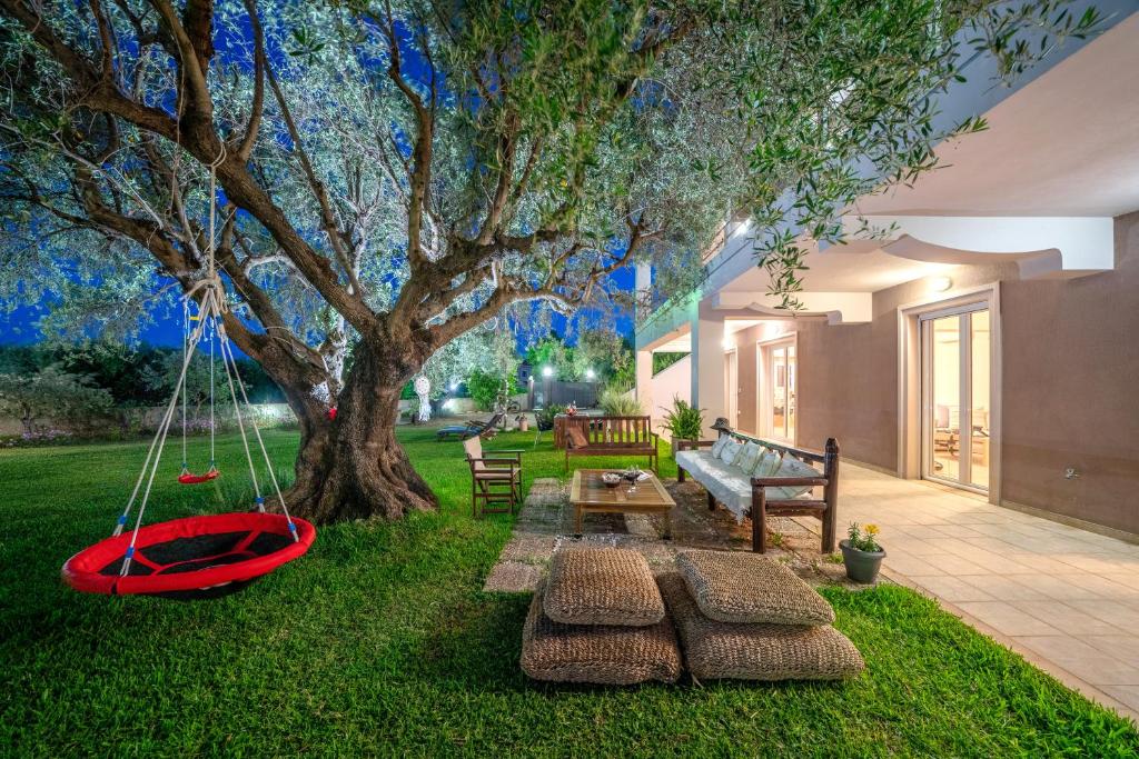 a yard with a swing under a tree at Cicada Home in Karavadhos