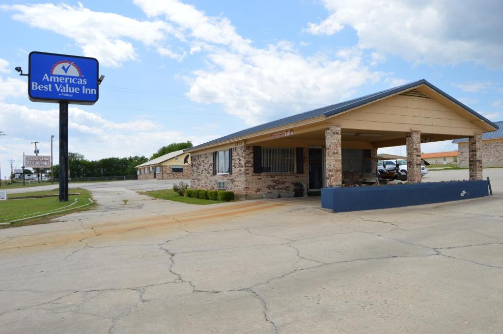 Americas Best Value Inn Gainesville TX في غينزفيل: مبنى امامه لافته