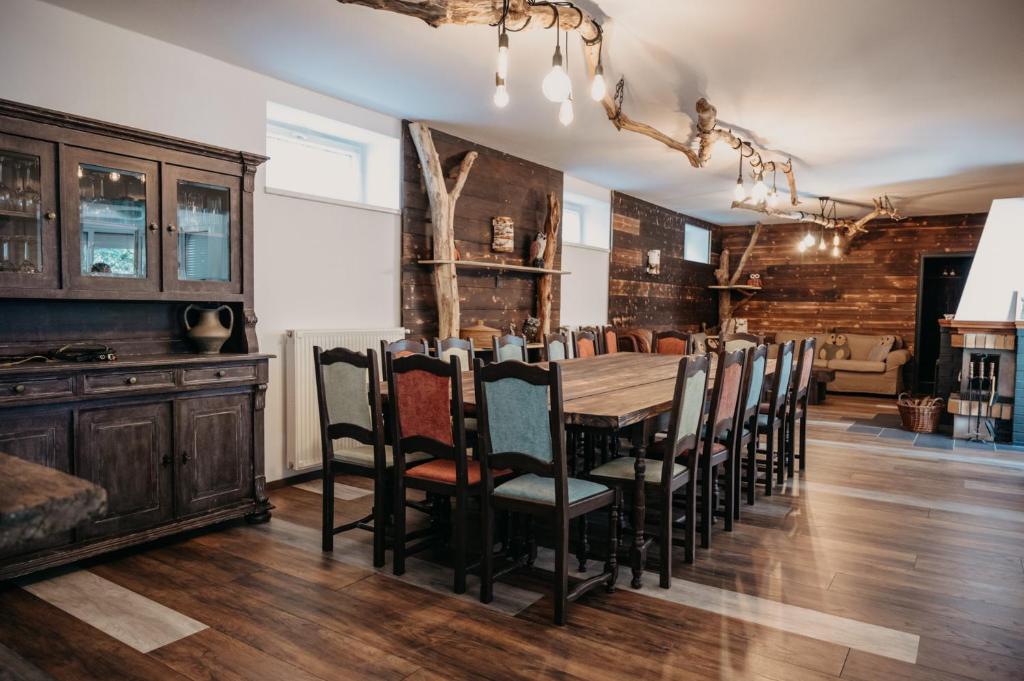 een eetkamer met een houten tafel en stoelen bij Foltos Bagoly Vendégház in Bagolyirtás