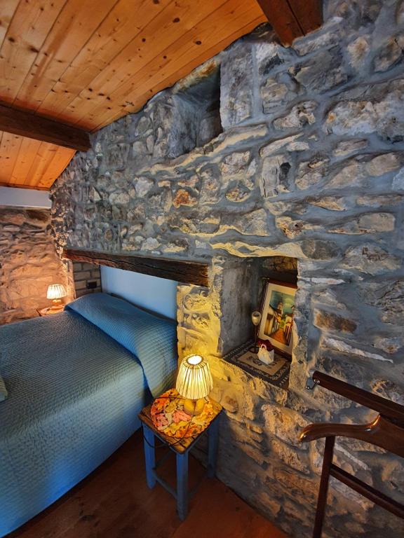 - une chambre avec un lit dans un mur en pierre dans l'établissement Le Casite Bed & Breakfast, à Trieste