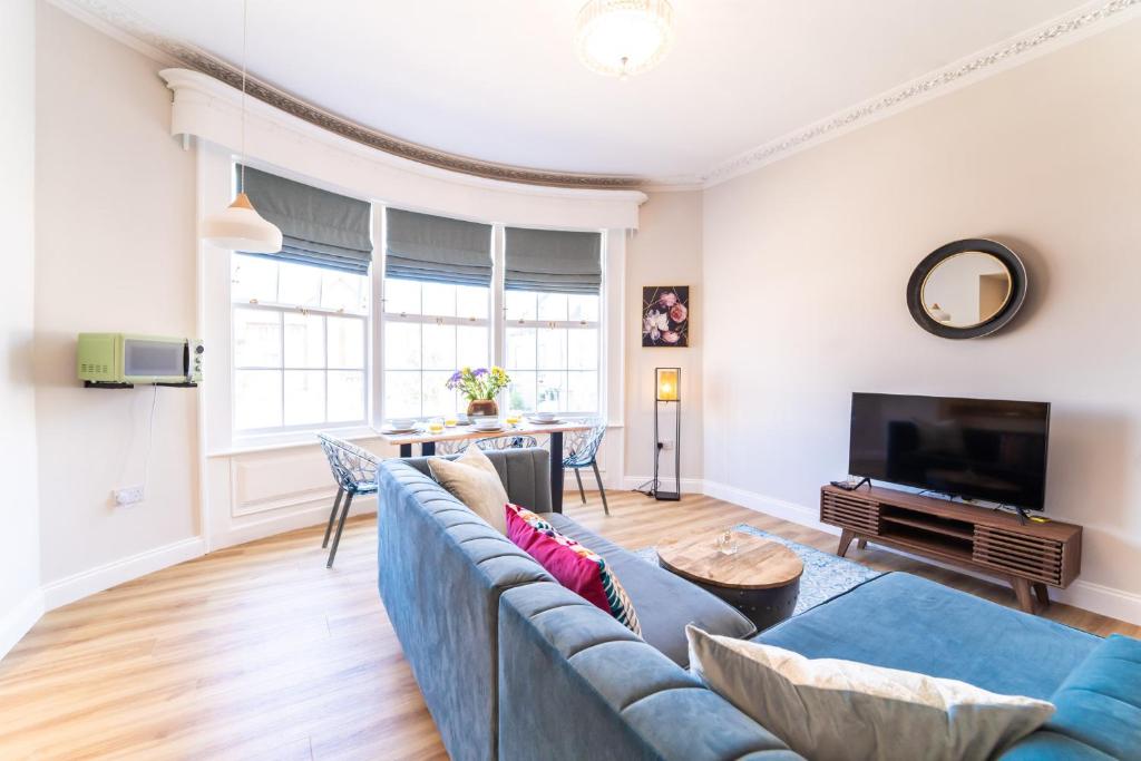 a living room with a blue couch and a tv at King Street Residence - 2 Bed in Great Yarmouth