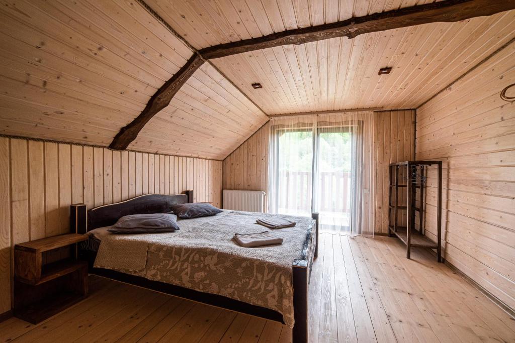 a bedroom with a bed in a wooden room at Villa Grace in Oryavchyk
