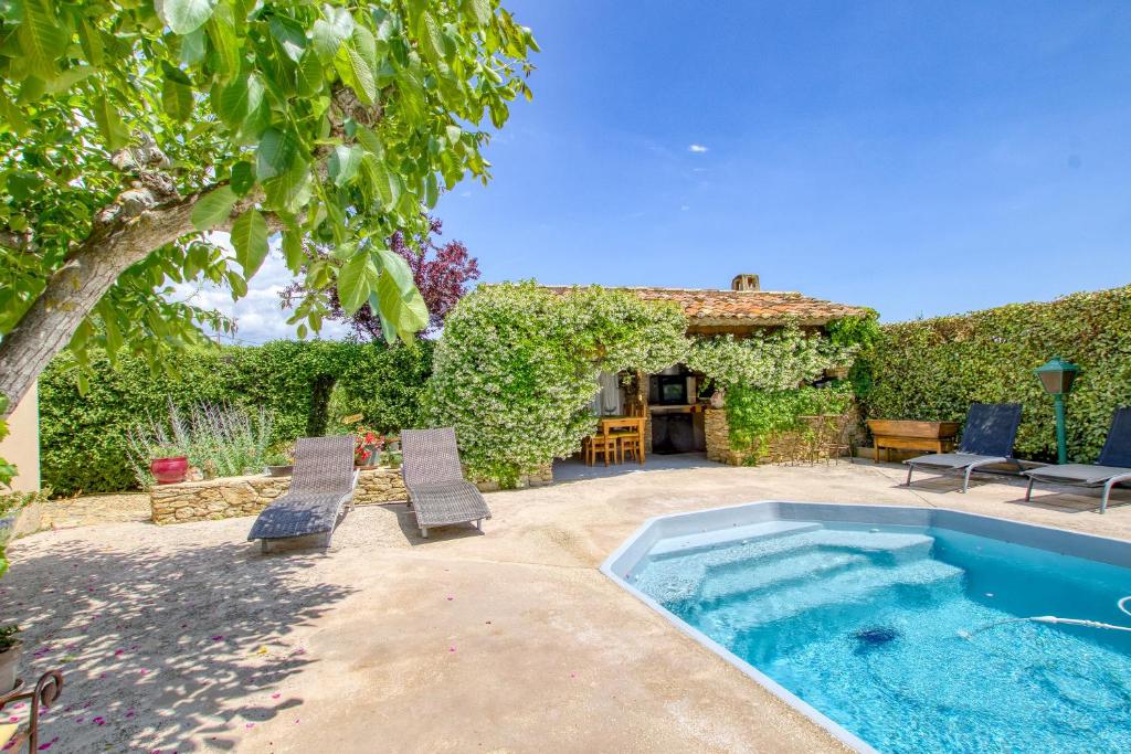 une cour arrière avec une piscine et deux chaises dans l'établissement Le Mas de la Noria, à La Cadière-dʼAzur