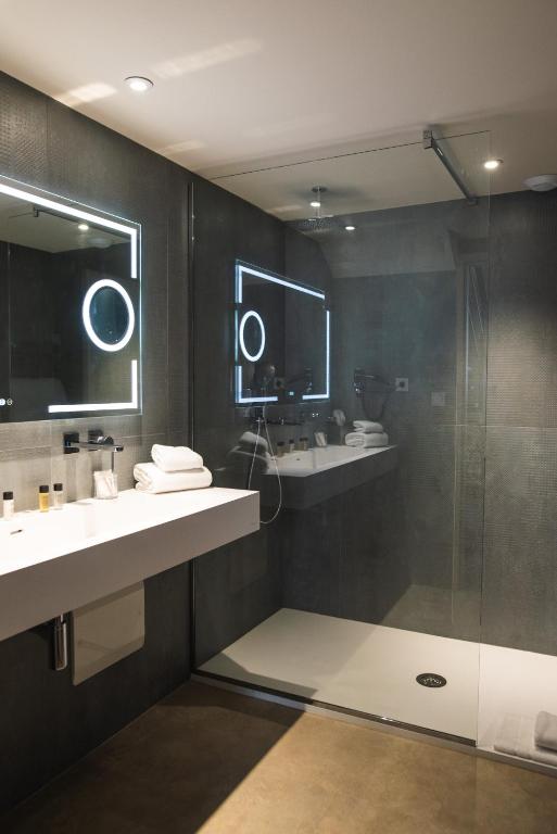 a bathroom with a shower and a sink and a mirror at Hôtel 1770 &amp; Spa in Le Pontet