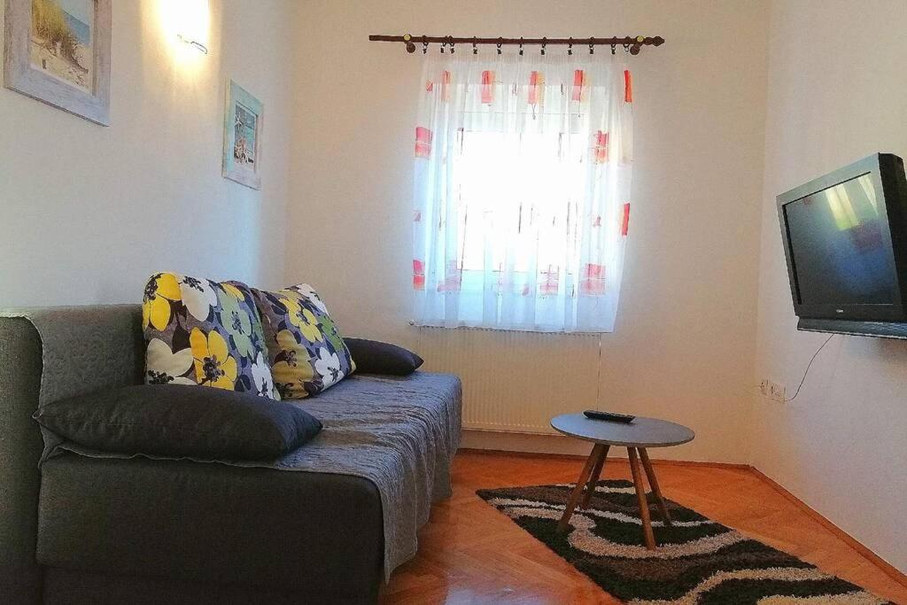 a living room with a couch and a tv at Apartment The View Costabella no.2 in Rijeka