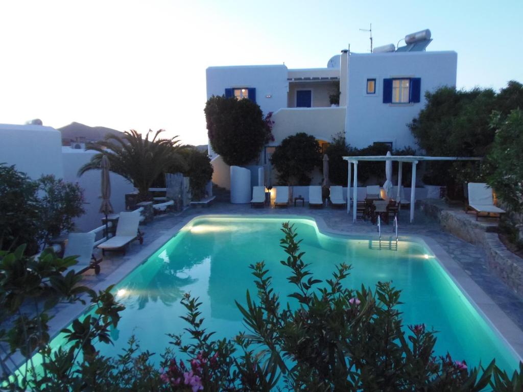 a villa with a swimming pool in front of a house at Hotel Manos in Naousa