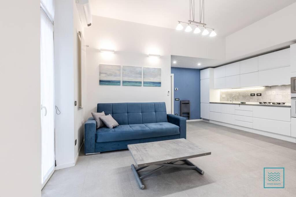 a living room with a blue couch and a table at Appartamento incantevole Lido di Ostia- Corallo Azzurro in Lido di Ostia