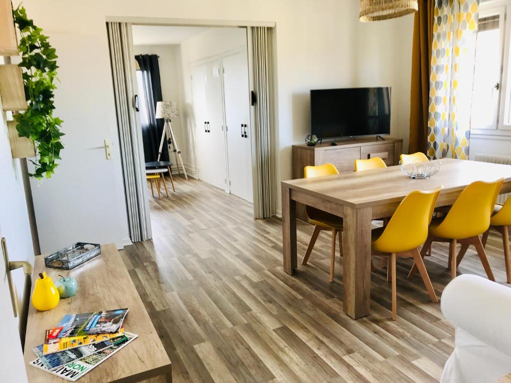 Le Foch في اويسترهام: غرفة معيشة مع طاولة طعام وكراسي صفراء