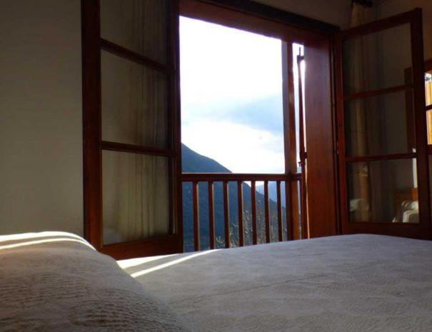 ein Schlafzimmer mit einem Bett und einem großen Fenster in der Unterkunft Casa planominguero in Taull