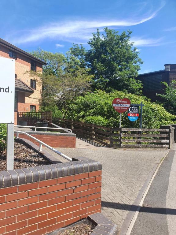 a brick wall next to a building with signs at Stunning 1-Bed Apartment in Walsall in Walsall