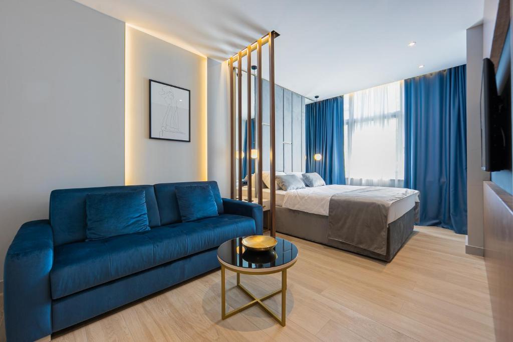 a living room with a blue couch and a bed at Caldo Luxury Rooms in Split