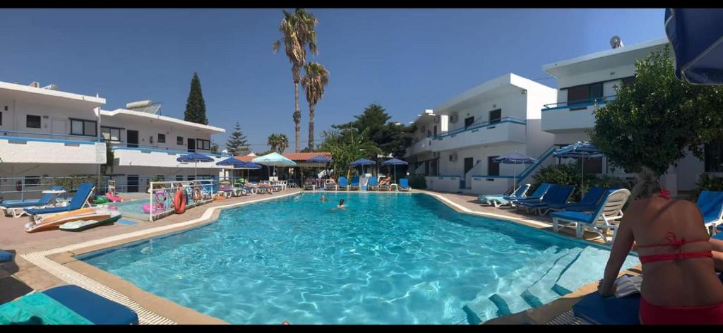 a swimming pool with chairs and people in a hotel at Giovanni Apartments Kos Studio 20 in Kos
