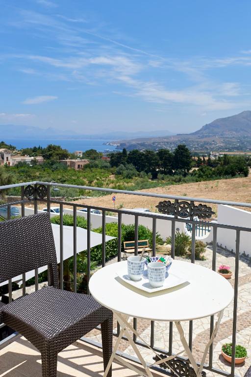 a table and chairs on a balcony with a view at Baglio Dello Zingaro in Scopello