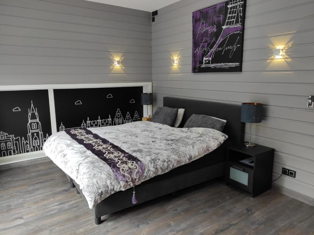 a bedroom with a bed with a black and white comforter at Kuai Guestroom Brugge in Bruges