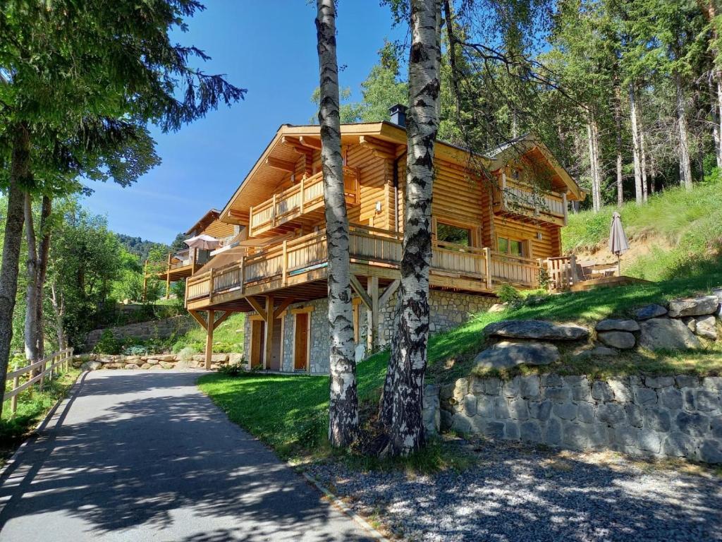 una cabaña de madera en el bosque con entrada en Chalet Les Sorbiers, en Égat