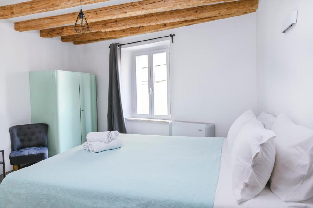 um quarto com uma cama grande e uma janela em M9 Rooms em Izola