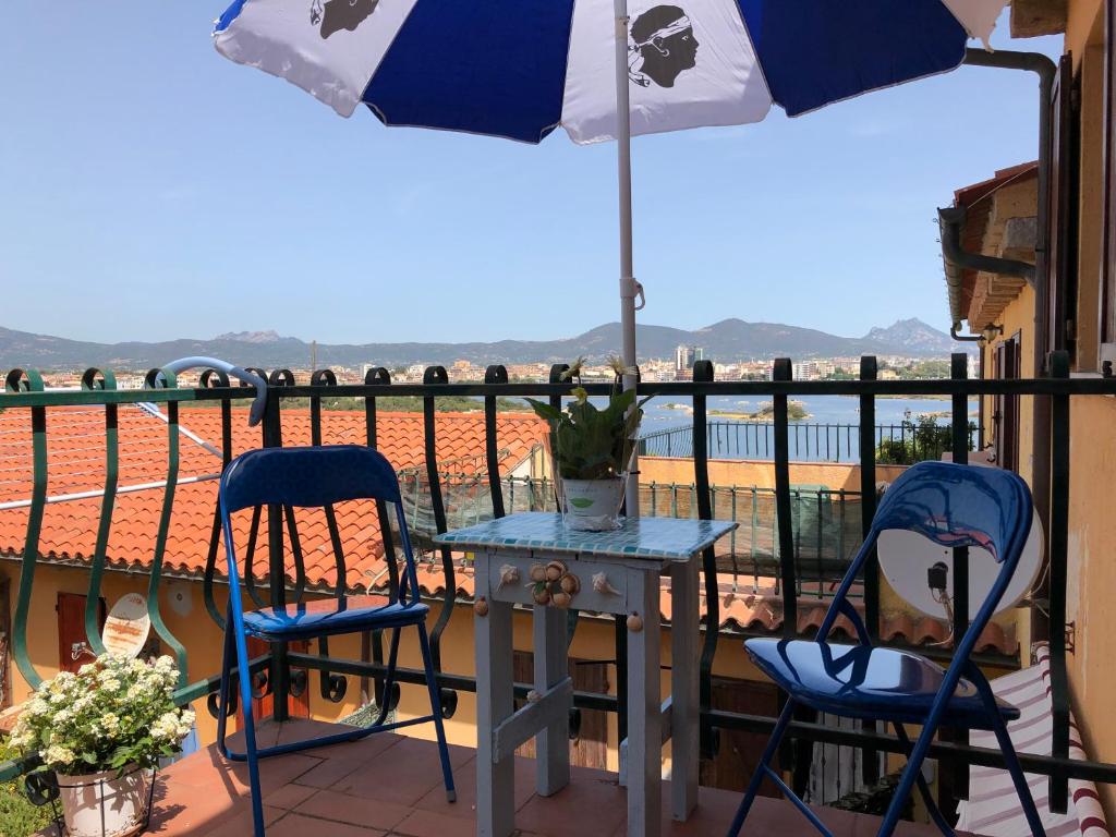 a table and chairs on a balcony with an umbrella at Peter's House Olbia in Olbia