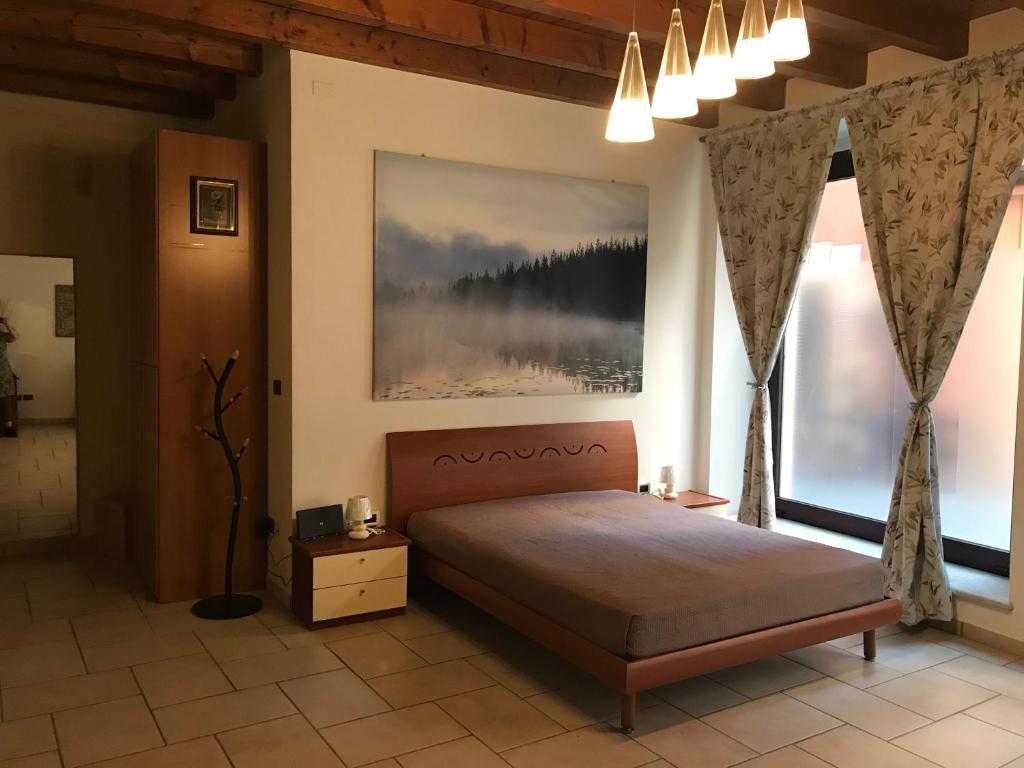 a bedroom with a bed and two large windows at KINDLY ROBERTA centro storico Peschiera,lago relax in Peschiera del Garda