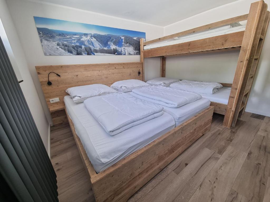 a bedroom with two bunk beds with white sheets at Appartement Rakké Kiefernweg Winterberg in Winterberg