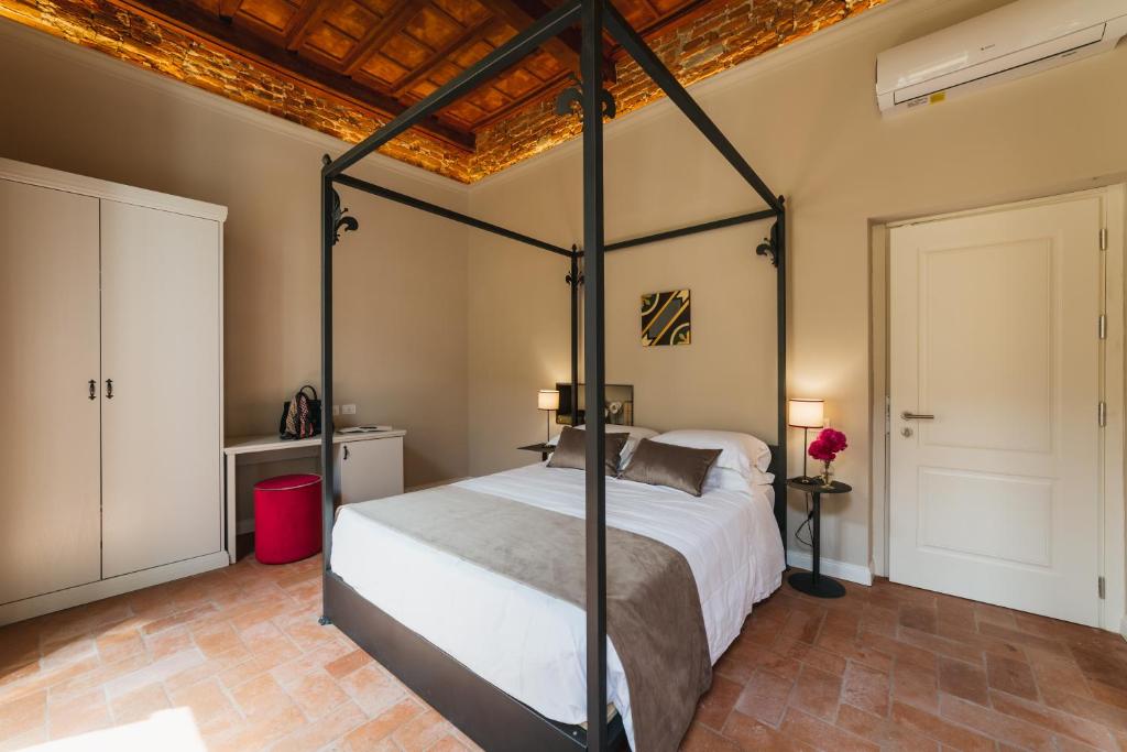 a bedroom with a four poster bed and a wooden ceiling at Atelier delle Grazie in Florence