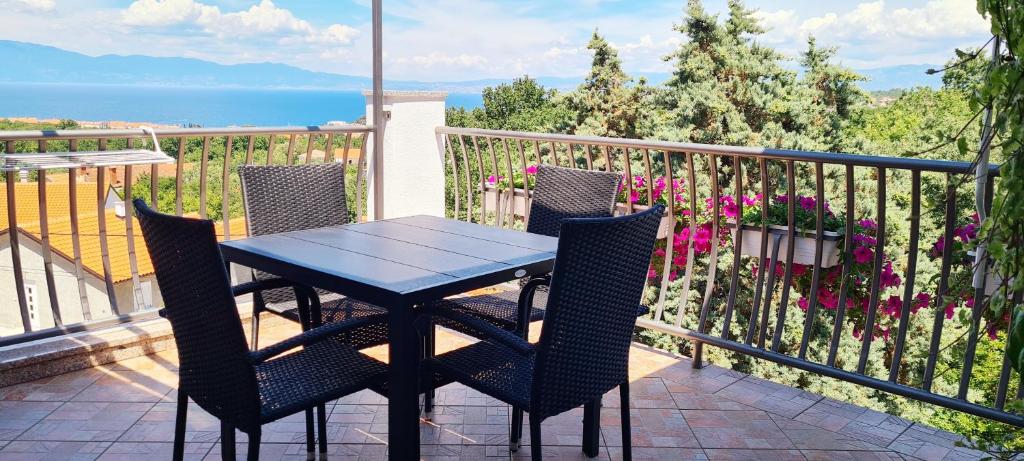 un tavolo e sedie su un balcone con vista sull'oceano di Studio Dora Malinska a Malinska